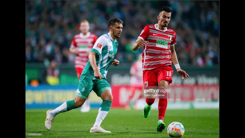 Cầu thủ Augsburg đang tung cú sút mạnh mẽ vào khung thành của Werder Bremen